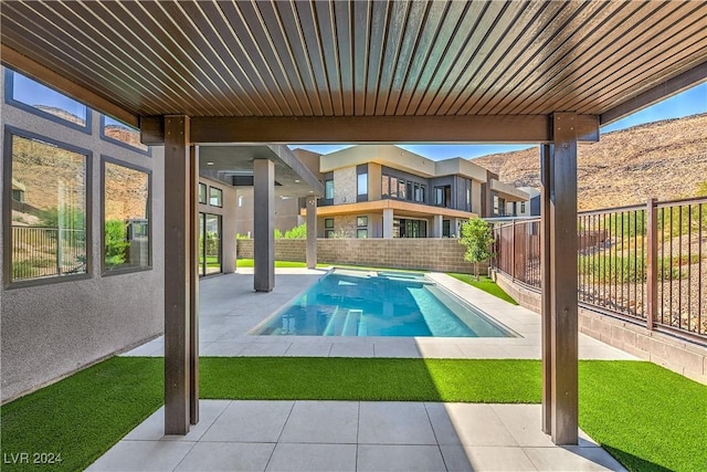 view of swimming pool with a mountain view, a patio, a fenced backyard, and a pool with connected hot tub