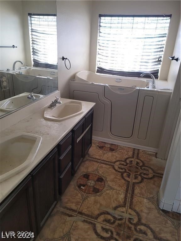 bathroom with vanity, tile patterned floors, and a bathing tub