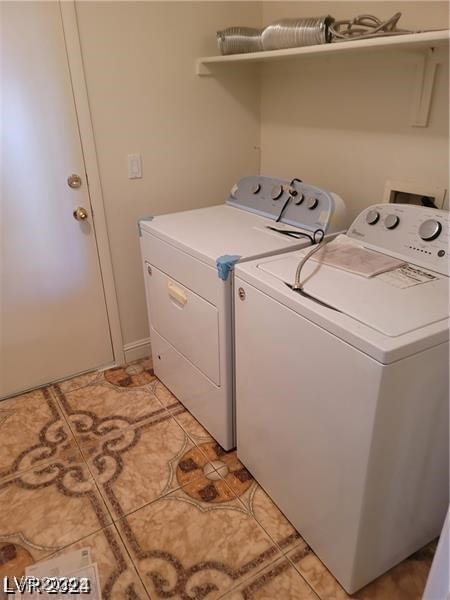 clothes washing area with independent washer and dryer and light tile patterned floors