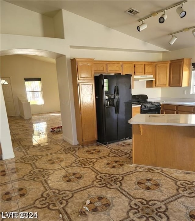 kitchen featuring light tile patterned flooring, lofted ceiling, black appliances, and rail lighting