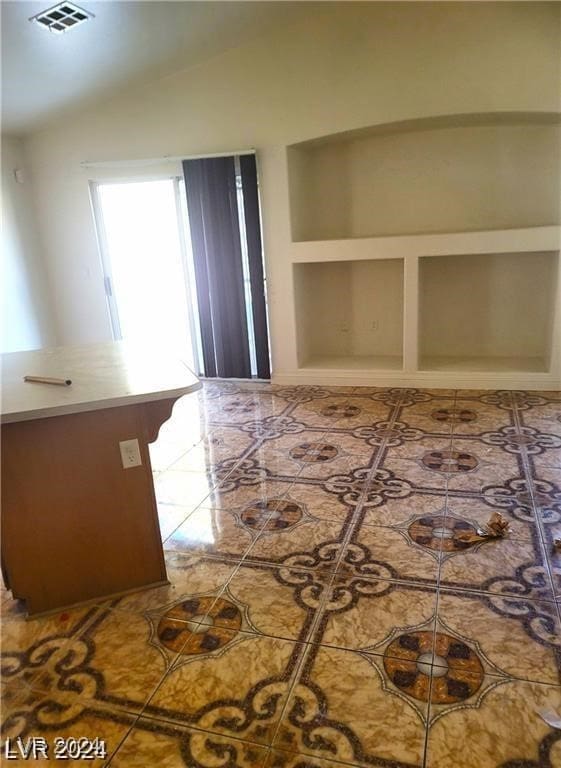 interior space with lofted ceiling and tile patterned floors