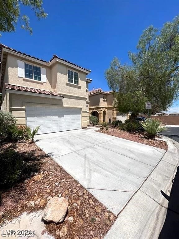 mediterranean / spanish-style home with a garage