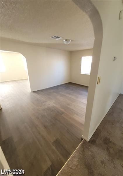 empty room featuring dark hardwood / wood-style floors and a textured ceiling