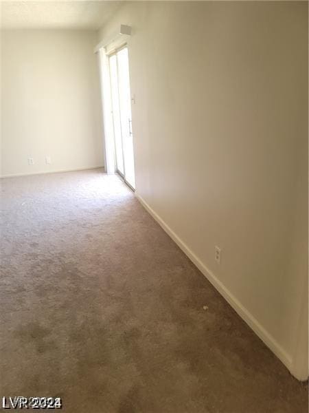 spare room with dark carpet