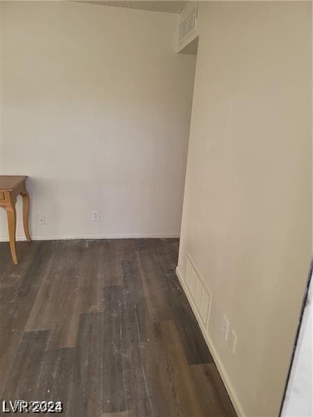 unfurnished room with dark wood-type flooring