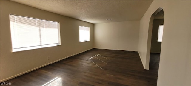 empty room featuring dark hardwood / wood-style floors and a textured ceiling