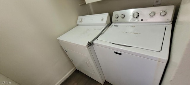 clothes washing area featuring dark hardwood / wood-style flooring and washer and clothes dryer