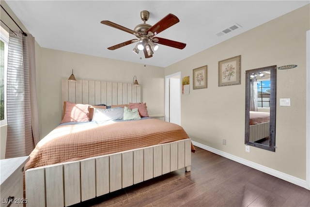 bedroom featuring multiple windows, dark hardwood / wood-style floors, and ceiling fan