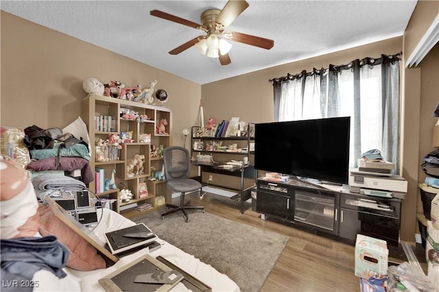 office with a textured ceiling, light hardwood / wood-style floors, and ceiling fan