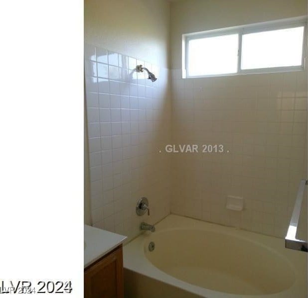 bathroom featuring vanity and tiled shower / bath