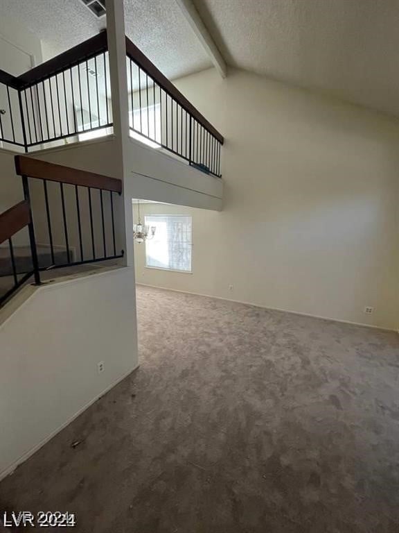 unfurnished living room with beam ceiling, a textured ceiling, carpet flooring, and high vaulted ceiling