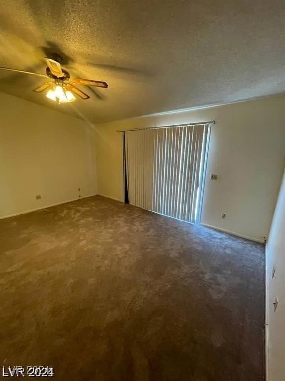 carpeted spare room with a textured ceiling and ceiling fan