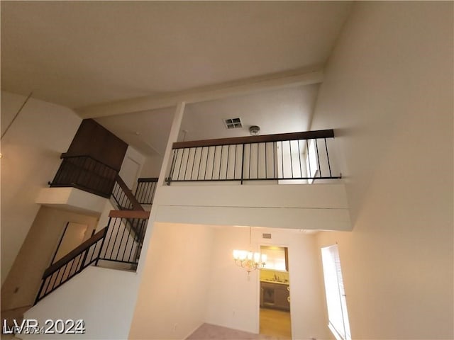 stairway featuring a notable chandelier and a towering ceiling