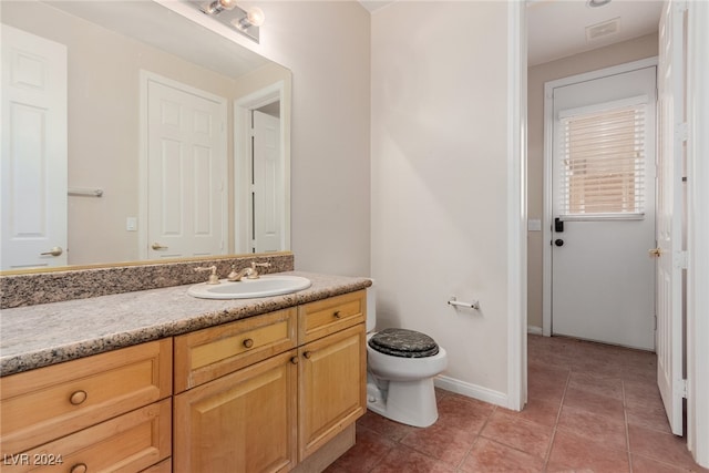 bathroom with vanity, toilet, and tile patterned floors