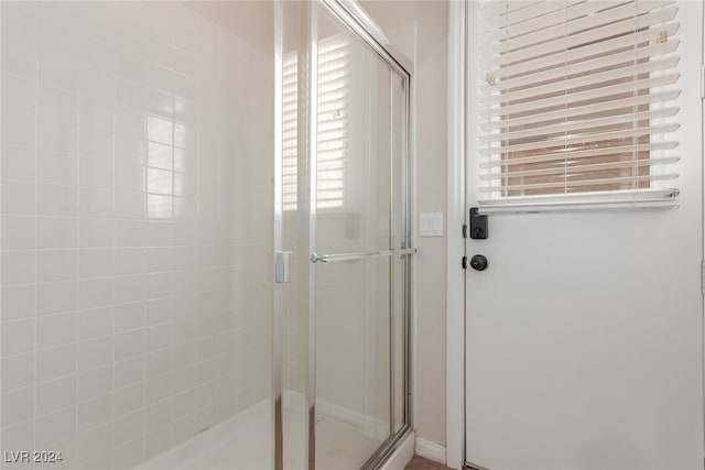 bathroom with a shower with door