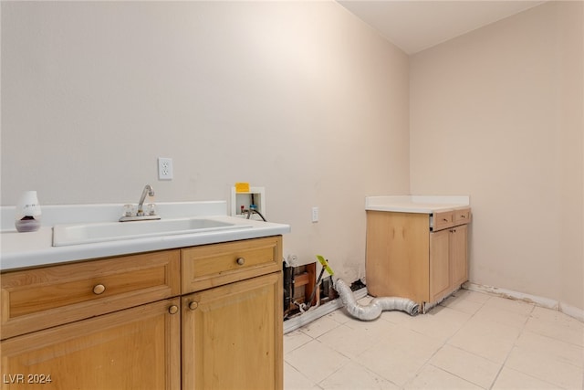 laundry area with sink, washer hookup, light tile patterned floors, and cabinets