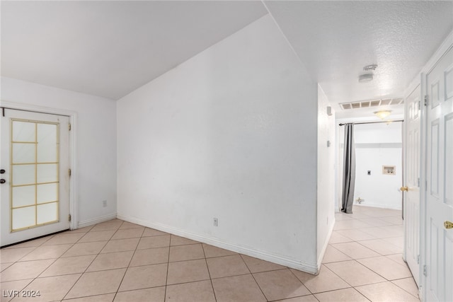 tiled spare room with a textured ceiling