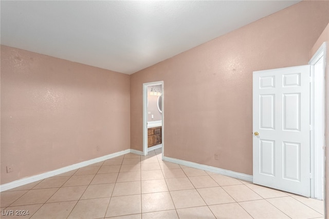 tiled spare room with vaulted ceiling