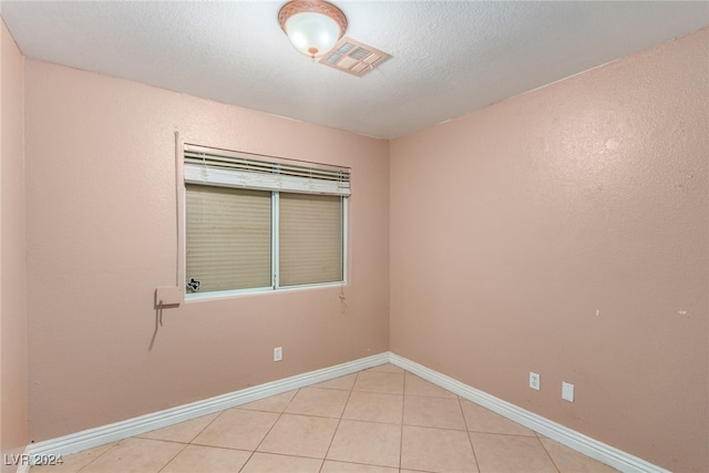 tiled spare room with a textured ceiling