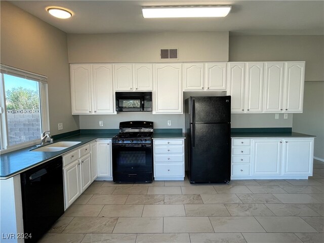 kitchen with sink, black appliances, and white cabinets