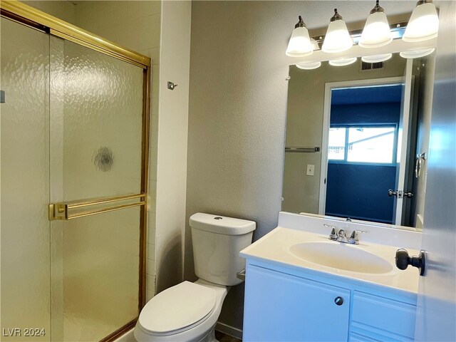 bathroom with a shower with door, toilet, and vanity