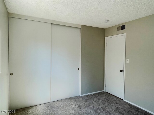 unfurnished bedroom with a textured ceiling and a closet