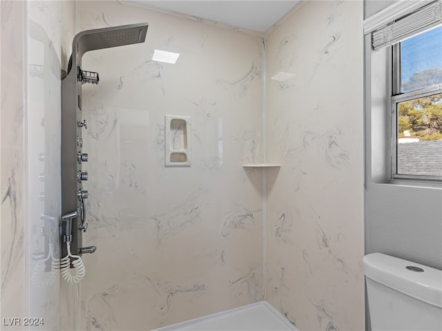 bathroom featuring toilet and a tile shower