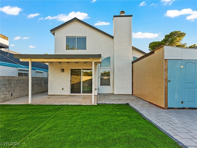 rear view of property featuring a lawn and a patio area