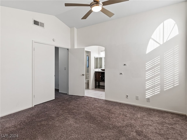 unfurnished bedroom with ceiling fan, a closet, carpet floors, and ensuite bath