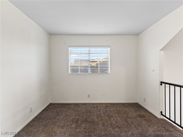 empty room featuring dark colored carpet