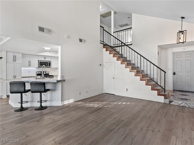 living room with hardwood / wood-style floors and high vaulted ceiling