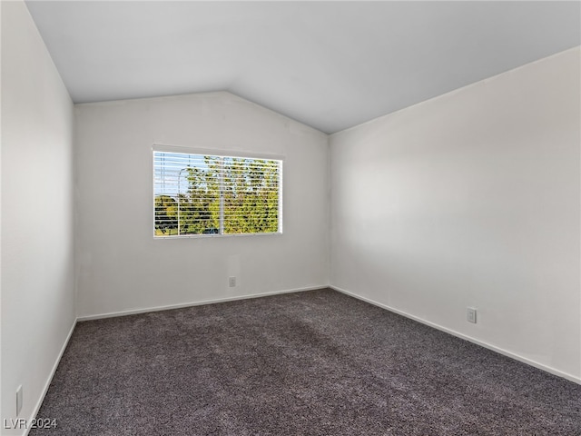 carpeted empty room with lofted ceiling