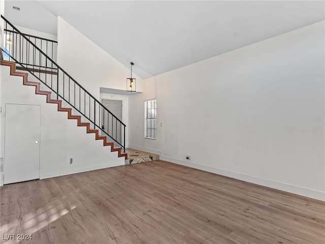 unfurnished living room with high vaulted ceiling and light hardwood / wood-style flooring