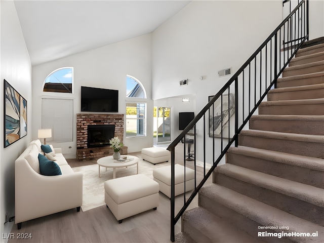 living room featuring light hardwood / wood-style floors, high vaulted ceiling, and a brick fireplace