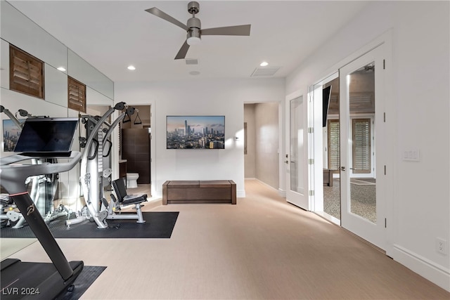 exercise area featuring ceiling fan, french doors, and light colored carpet