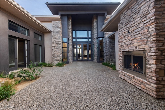 property entrance featuring an outdoor stone fireplace and french doors