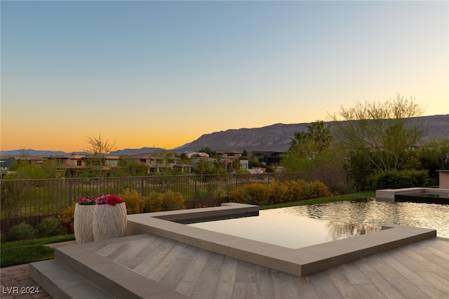 exterior space featuring a mountain view and a pool with hot tub