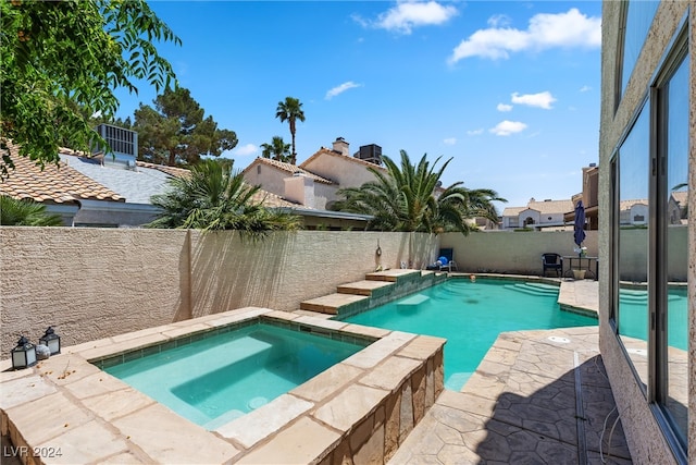 view of swimming pool featuring an in ground hot tub