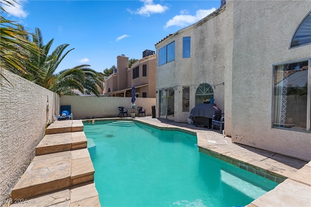 view of pool featuring area for grilling and a patio