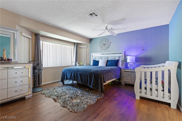 bedroom with dark wood-type flooring, a textured ceiling, and ceiling fan