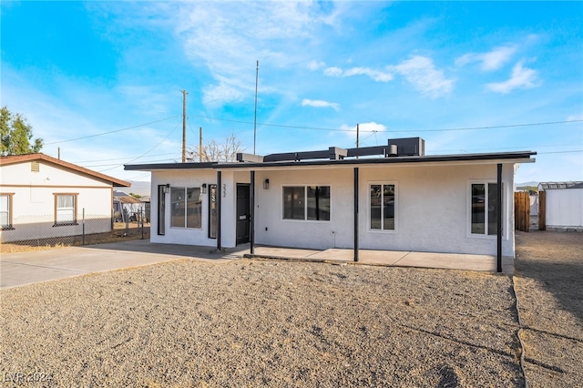 rear view of house featuring central air condition unit and a patio