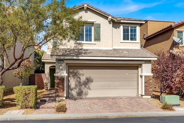 view of front of property with a garage and cooling unit