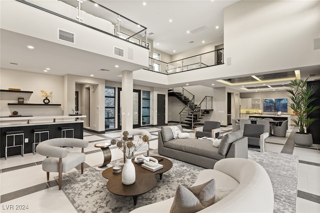 living room featuring a towering ceiling and light tile patterned floors