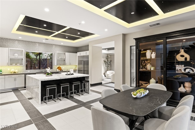 tiled dining room featuring a tray ceiling