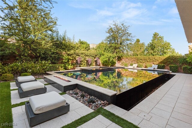 view of pool with an in ground hot tub and a patio area