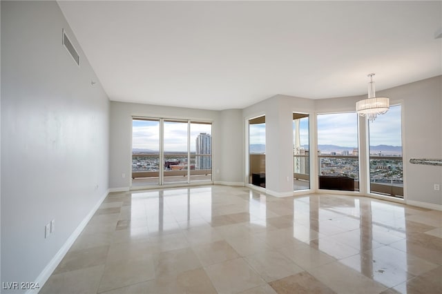 unfurnished room with light tile patterned floors and a notable chandelier