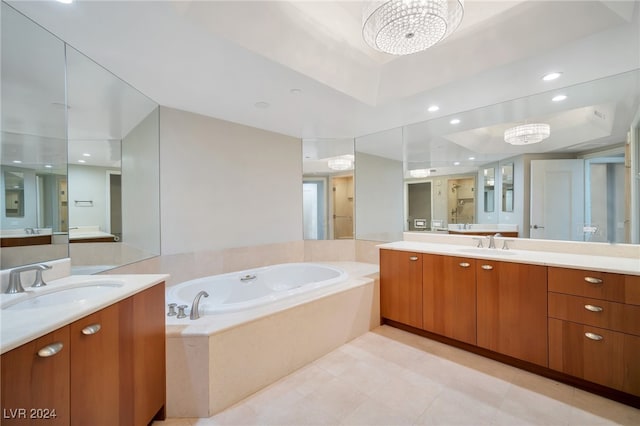 bathroom with a chandelier, vanity, and a relaxing tiled tub