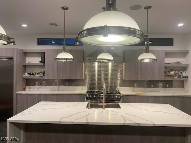 kitchen featuring light stone countertops, decorative backsplash, wall chimney range hood, and stainless steel appliances