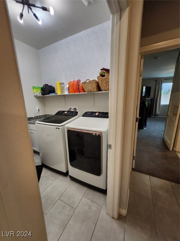 clothes washing area featuring washer and dryer and light tile patterned floors