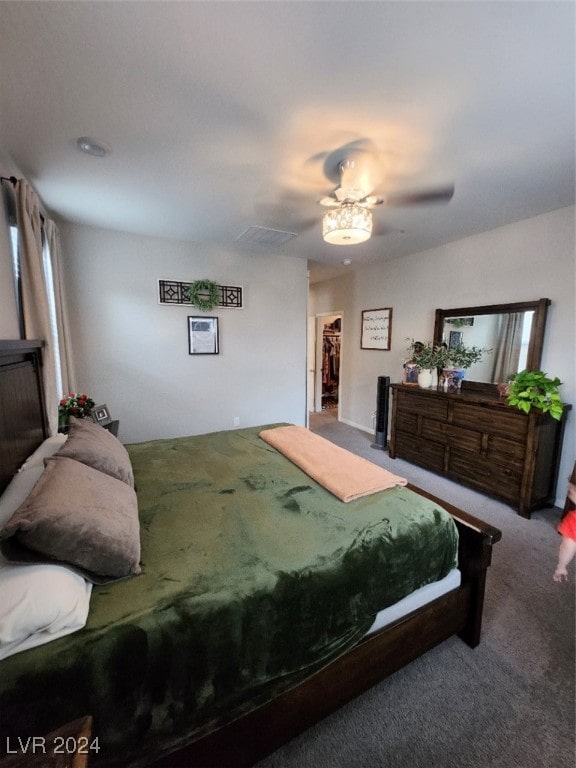 bedroom with a closet, carpet floors, a spacious closet, and ceiling fan